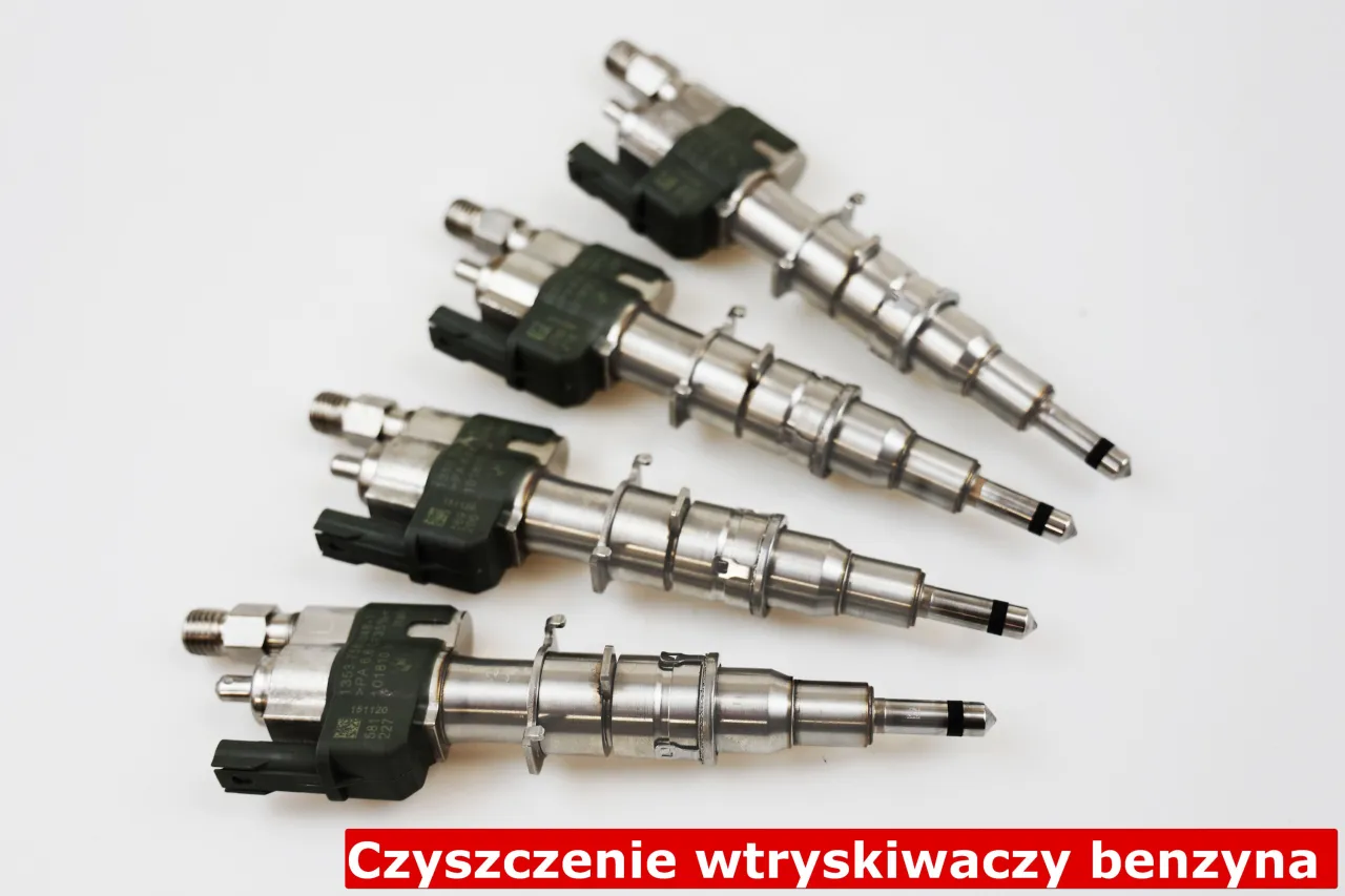 Czyszczenie wtryskiwaczy benzynowych: cztery metalowe wtryskiwacze z zielonymi złączami na białym tle.