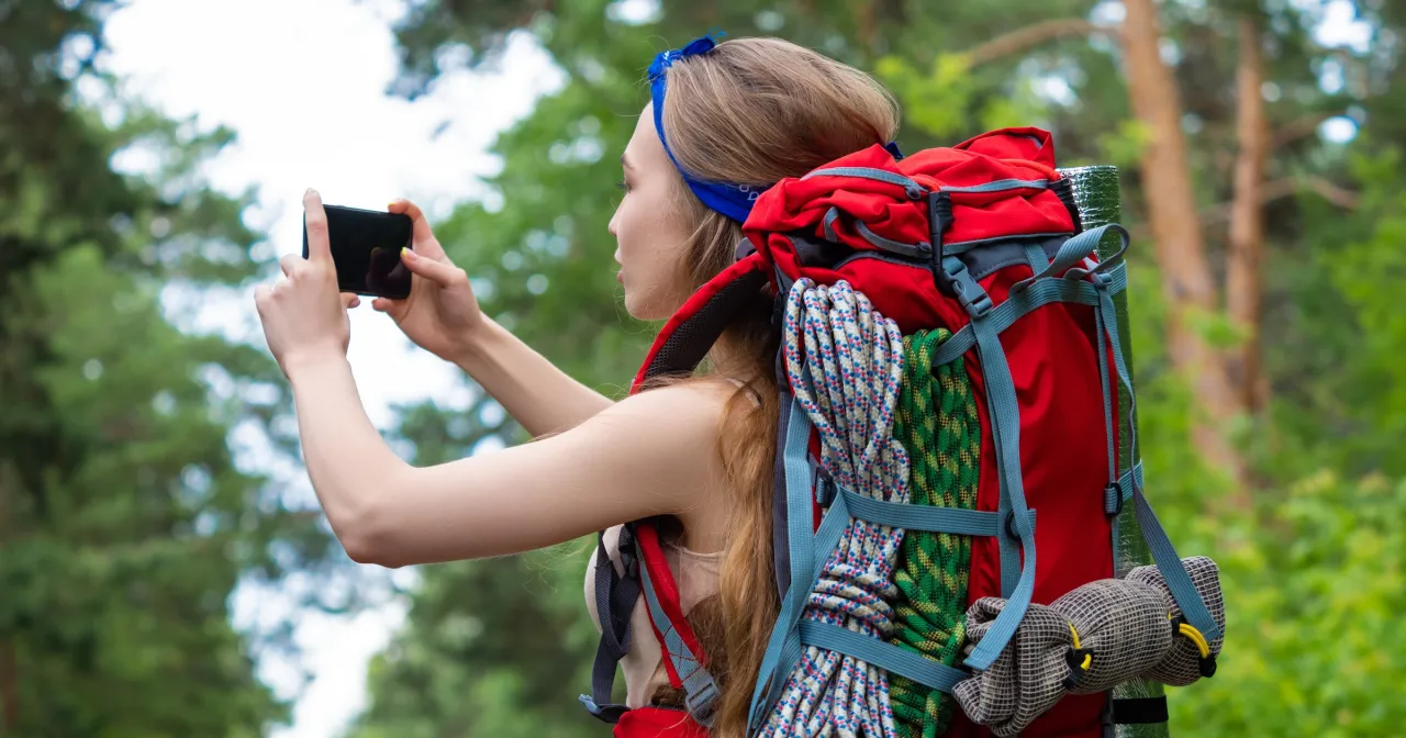 Turysta sprawdza mapę i telefon w górach