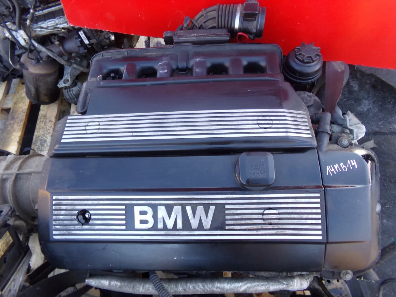 Silnik BMW E46 lift, widoczny z g&oacute;ry, z napisem BMW na pokrywie zawor&oacute;w.