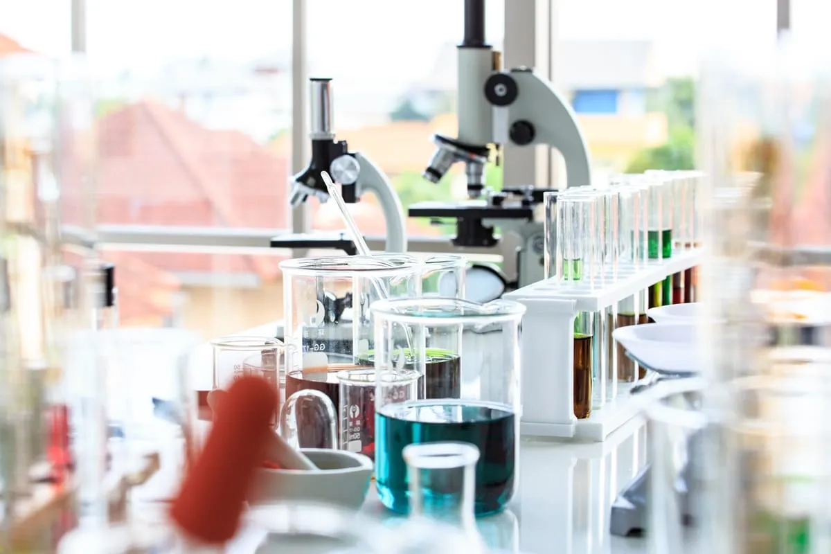 W tym laboratorium mikrobiologicznym badamy pr&oacute;bki pod mikroskopem, używając prob&oacute;wek i zlewki.