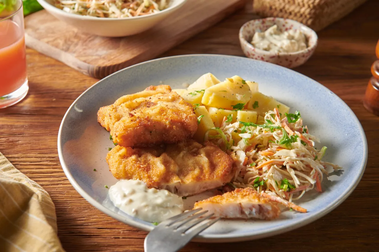 smażony mintaj z ziemniakami i surówką na talerzu