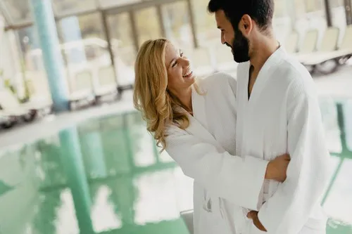 osoba w szlafroku idąca korytarzem hotelowym