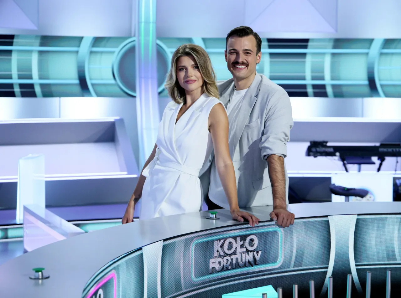Prowadzący Koło Fortuny, zapytani dlaczego zmiana prowadzącego, pozują na tle studia.