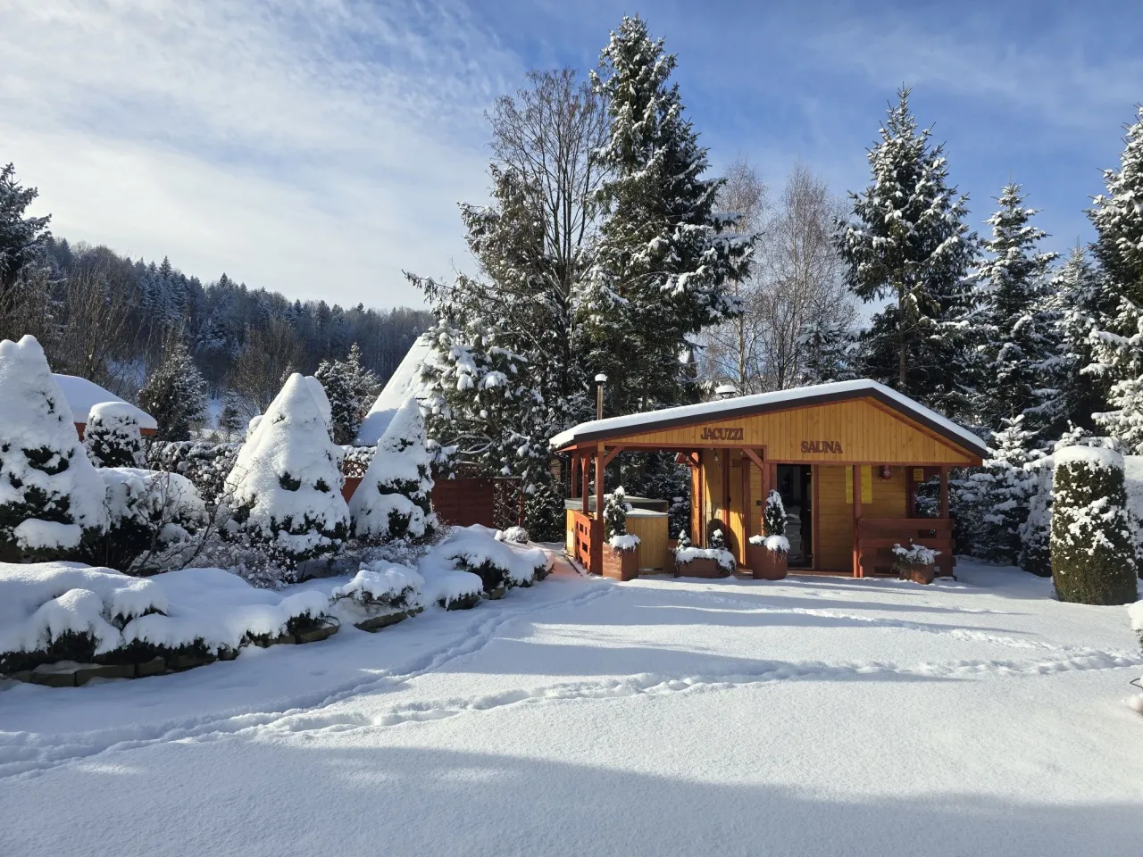 Zimowy krajobraz z domkiem jacuzzi i sauną, idealne miejsce na nocleg w okolicach Babiej G&oacute;ry.
