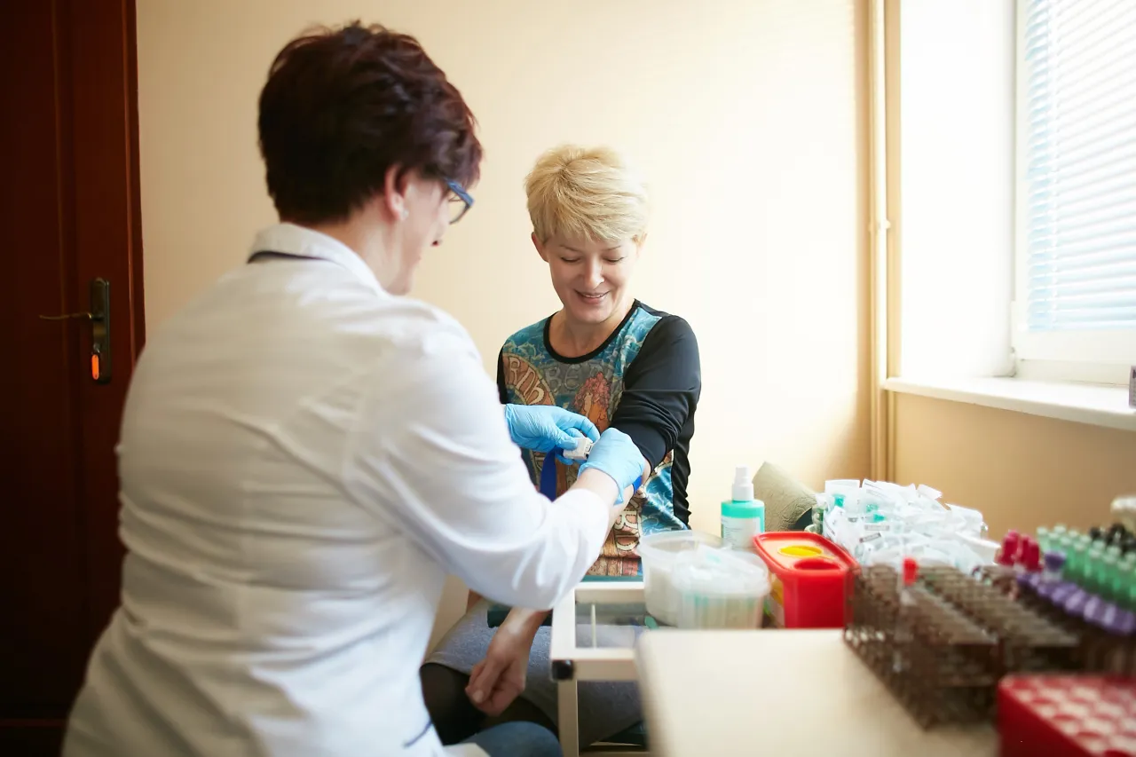 Kobieta odbierająca wyniki badań w laboratorium medycznym