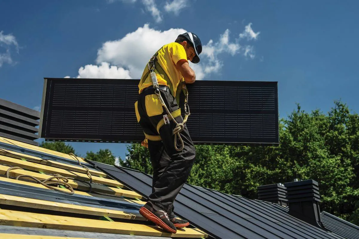dekarz montujący panele fotowoltaiczne na dachu lub zielony dach