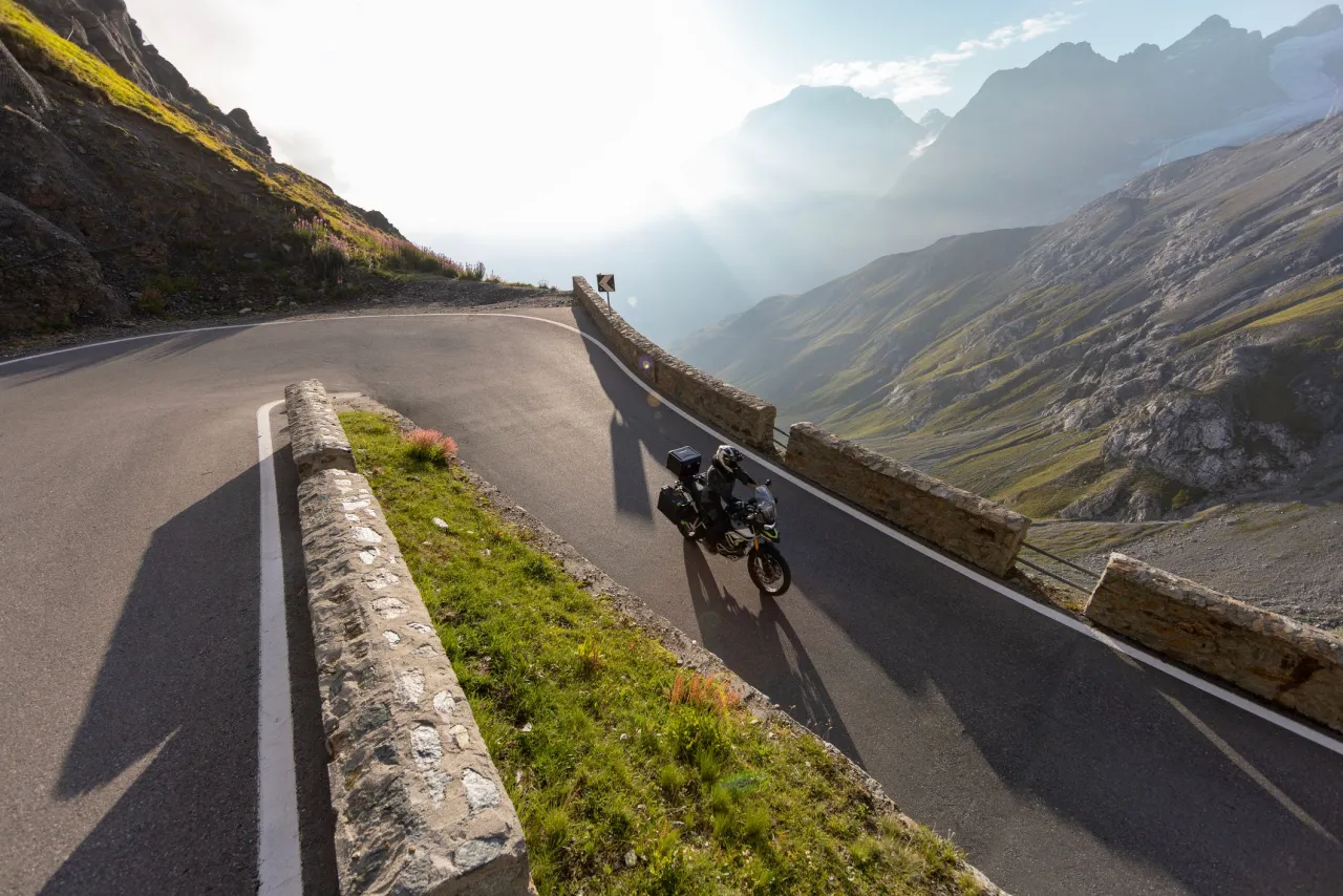 Motocyklista na alpejskiej przełęczy z zapierającym dech w piersiach widokiem