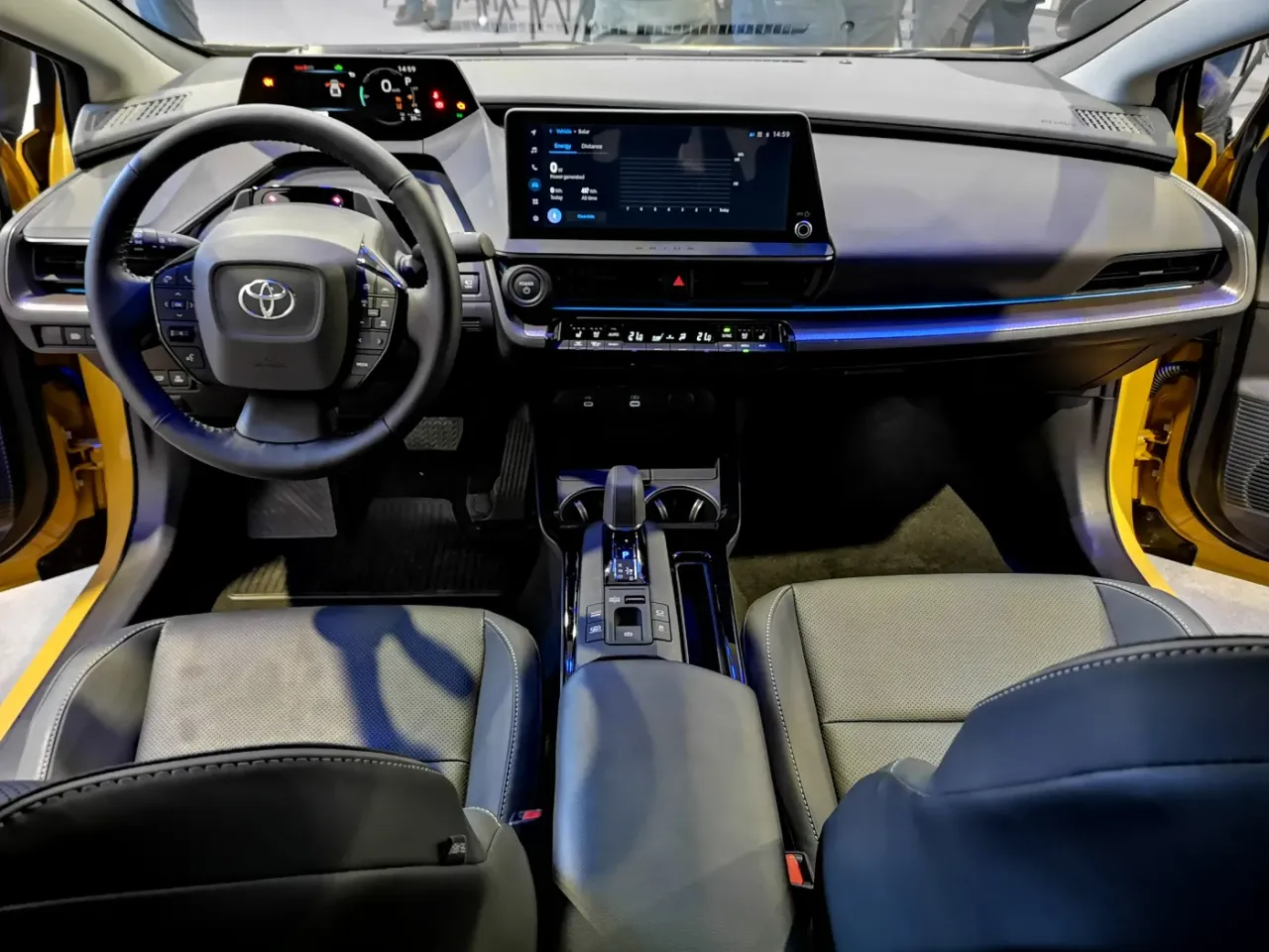 Wnętrze nowego Priusa w Polsce: nowoczesna deska rozdzielcza, ekran multimedi&oacute;w i komfortowe fotele.