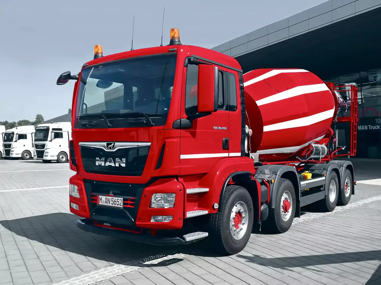 Czerwona gruszka betonu MAN TGS 35.460. Zastanawiasz się, ile kosztuje gruszka betonu? Ten potężny pojazd jest gotowy do pracy.
