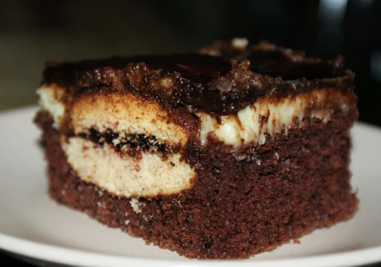 Pyszny kawałek ciasta z kremem i czekoladą, idealny na przepis na ciasto usta romana.