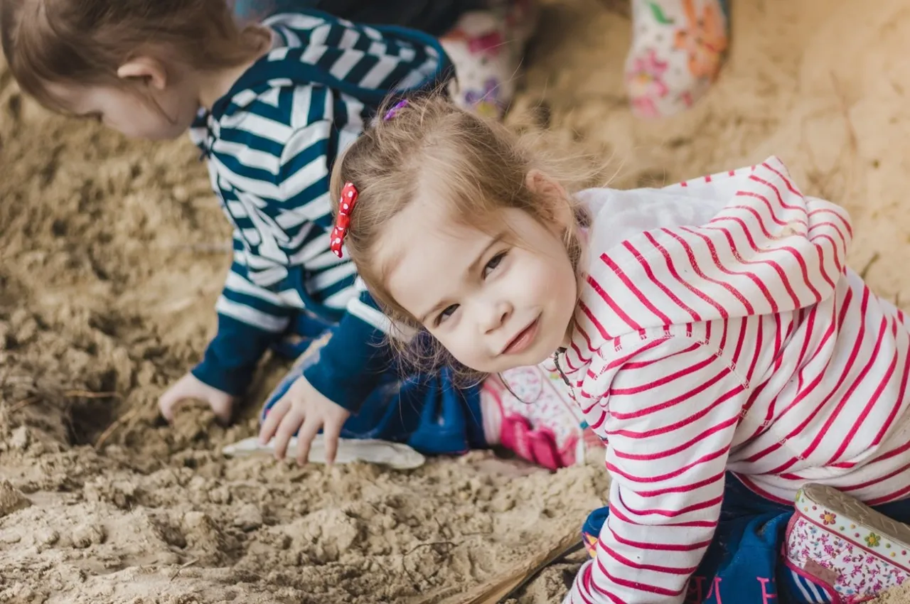dziecko 16 miesięcy bawi się na placu zabaw