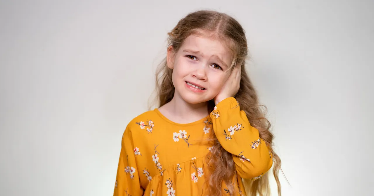 Dziecko reagujące na głośne dźwięki lub drapiącą metkę