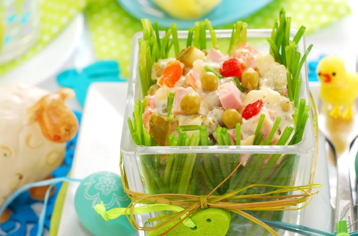 Sałatka jarzynowa w trawie z rzeżuchy, idealna na co na obiad wielkanocny. Obok baranek i pisanki.