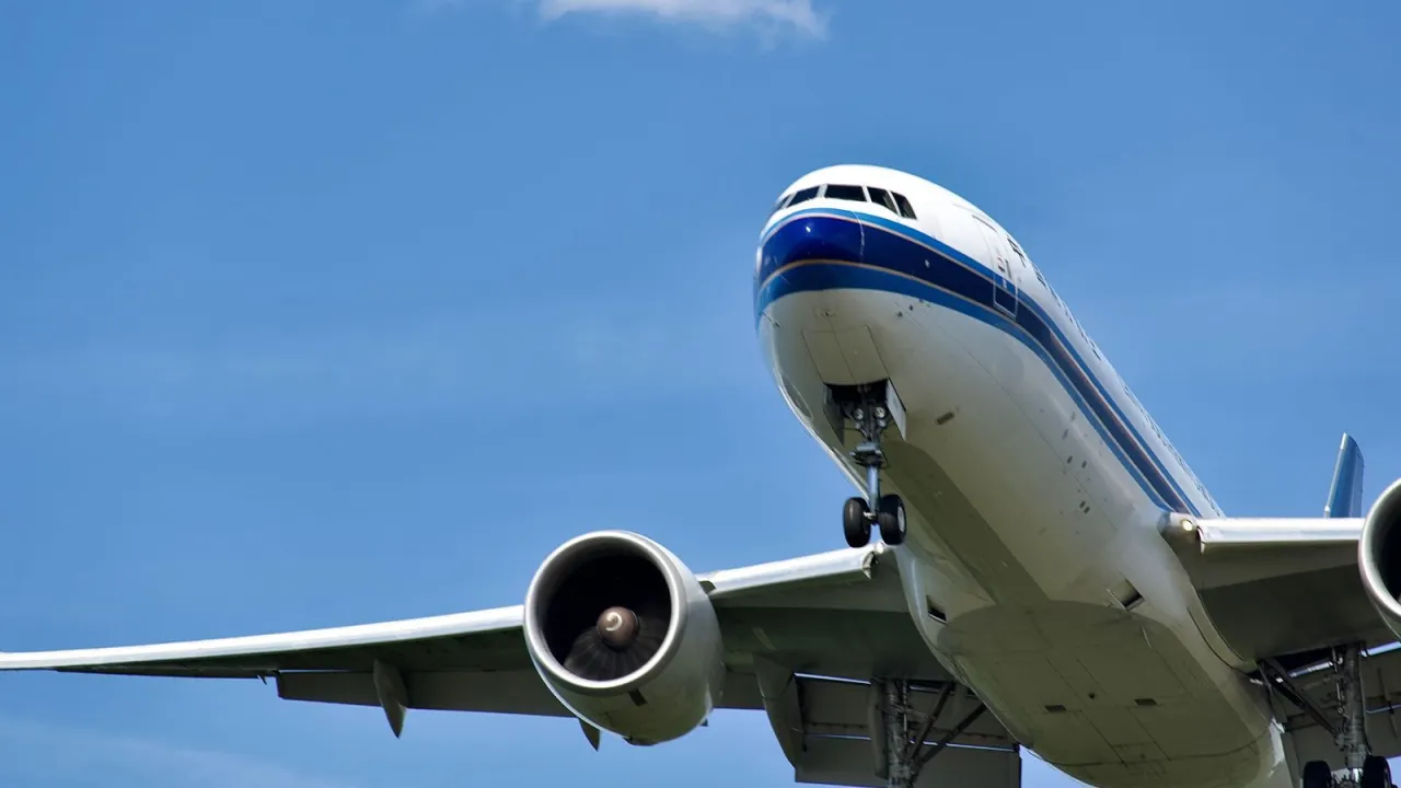 Samolot z wysuniętym podwoziem, gotowy do lądowania. Pasażerowie mogą liczyć na odszkodowanie za overbooking.