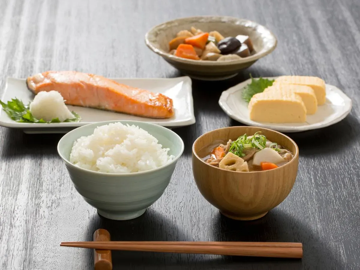 Tradycyjny japoński posiłek: ryż, grillowany łosoś, tamagoyaki (japoński omlet), zupa miso i warzywa. Takie dania często jedzą Japończycy na śniadanie.