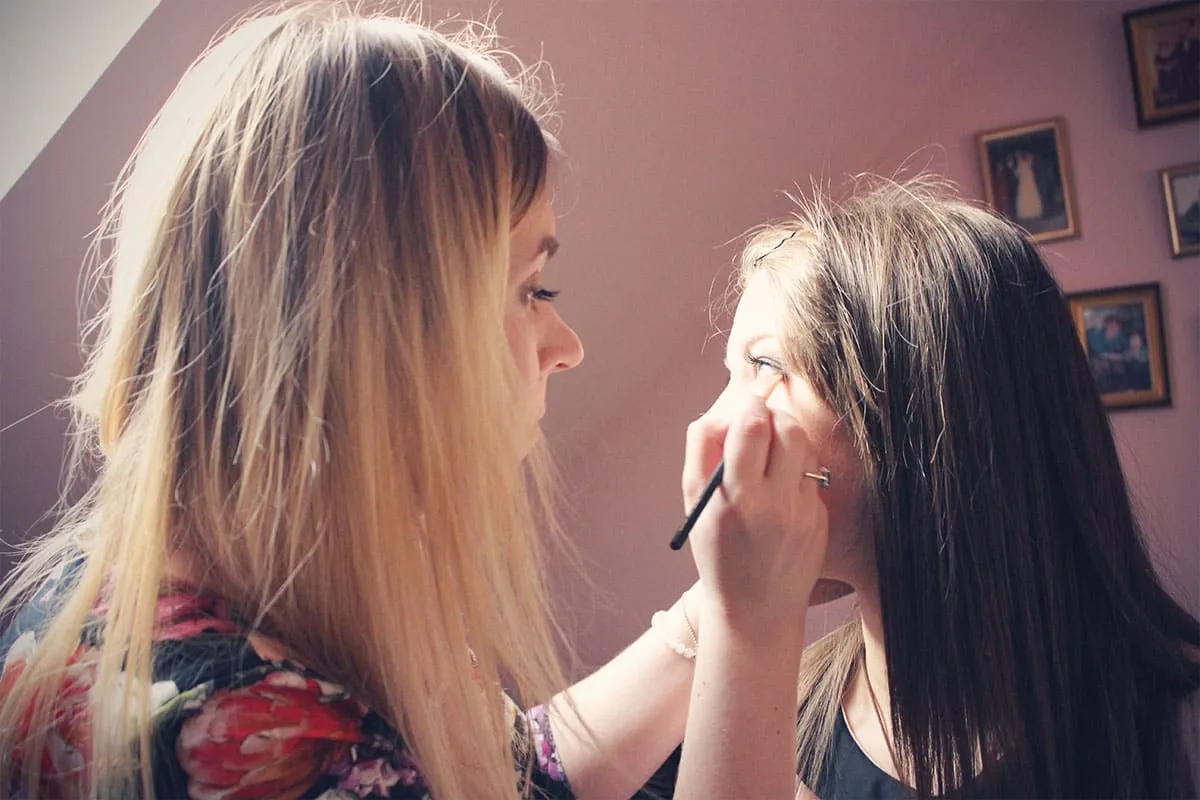 wizażystka wykonująca makijaż, zbliżenie na twarz klientki