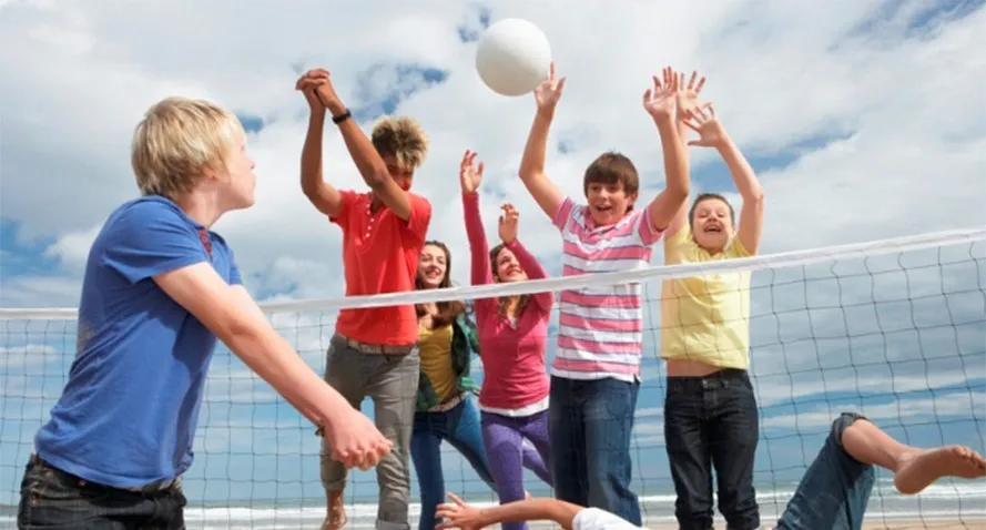 dzieci i dorośli grający w siatkówkę w klubie