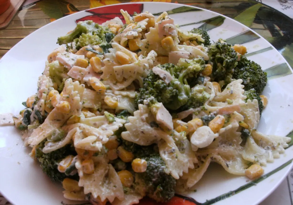 Pyszna sałatka z makaronem farfalle, brokułami, kukurydzą i kawałkami szynki w kremowym sosie. Idealna inspiracja, jak zrobić sałatkę z brokułami.