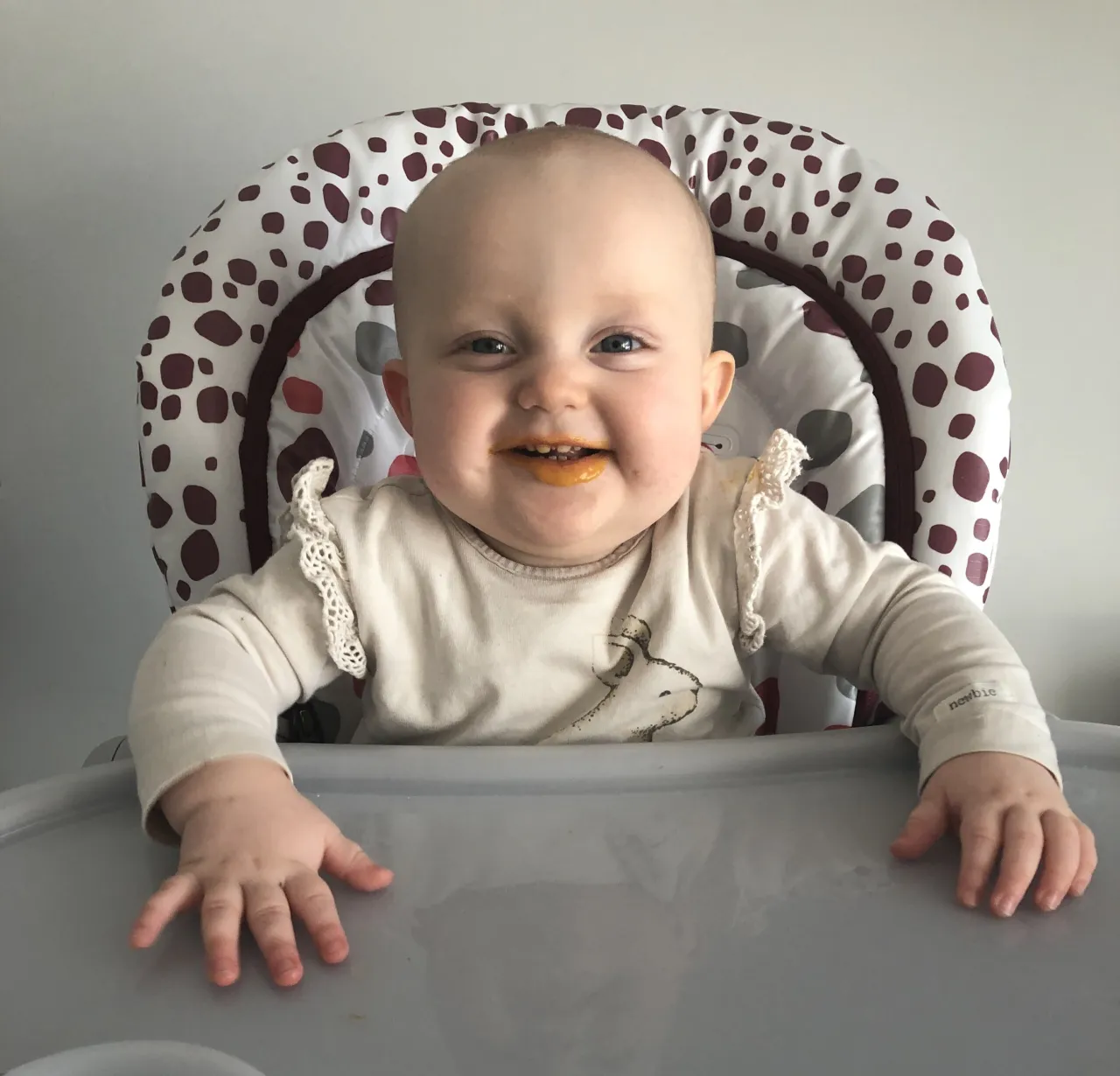 niemowlę siedzące i sięgające po jedzenie