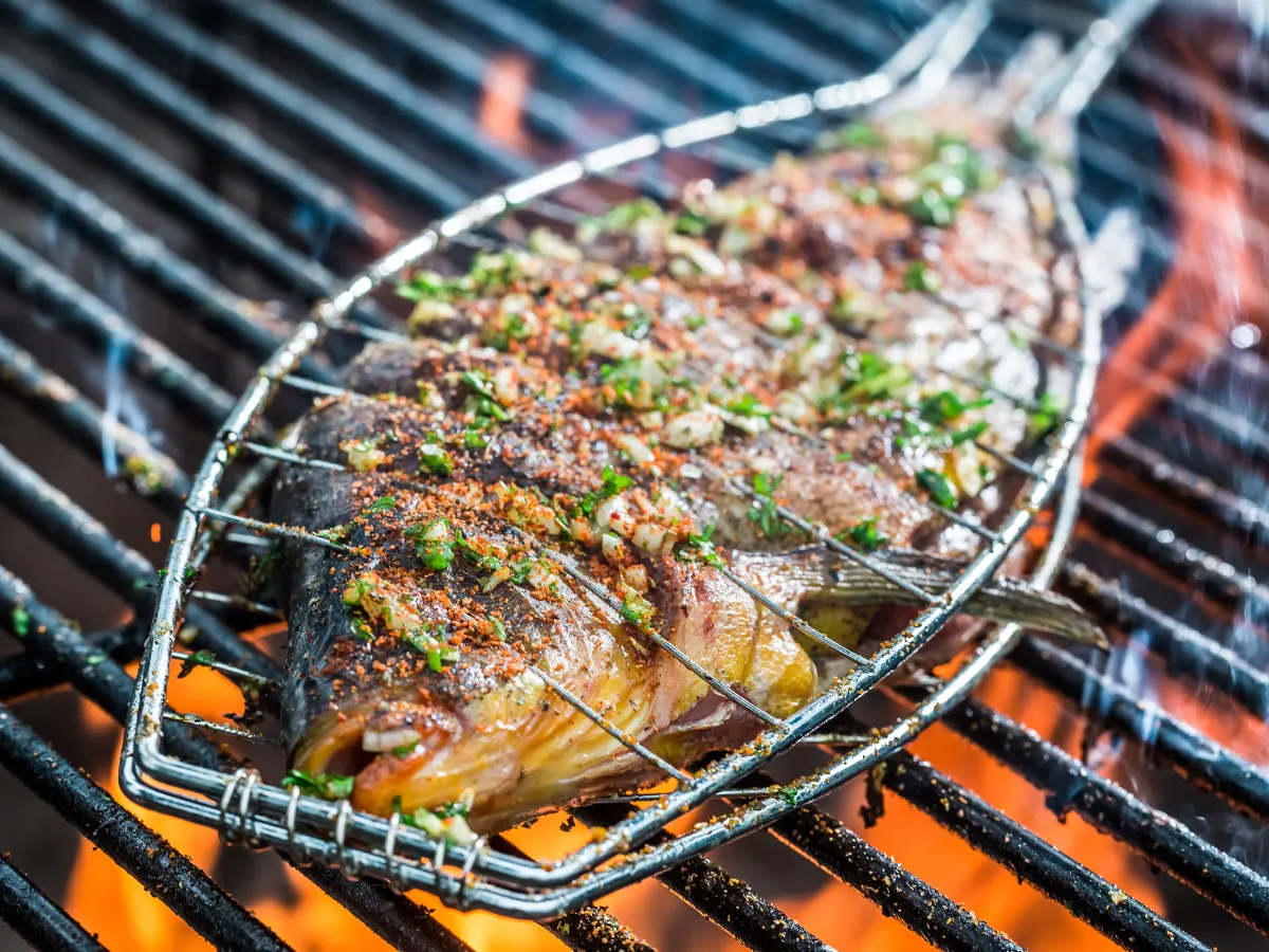 Cała ryba na grillu, przyprawiona ziołami i papryką, piecze się nad ogniem. Idealna ryba na grilla!