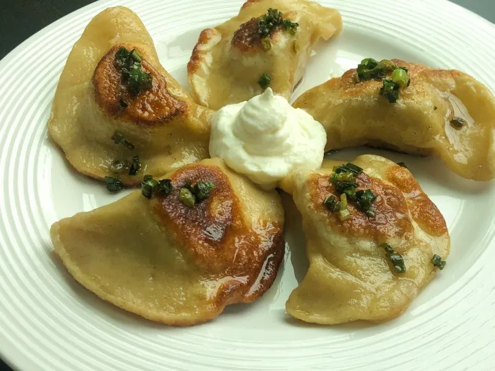 shoe polish next to a plate of Polish pierogi with labels