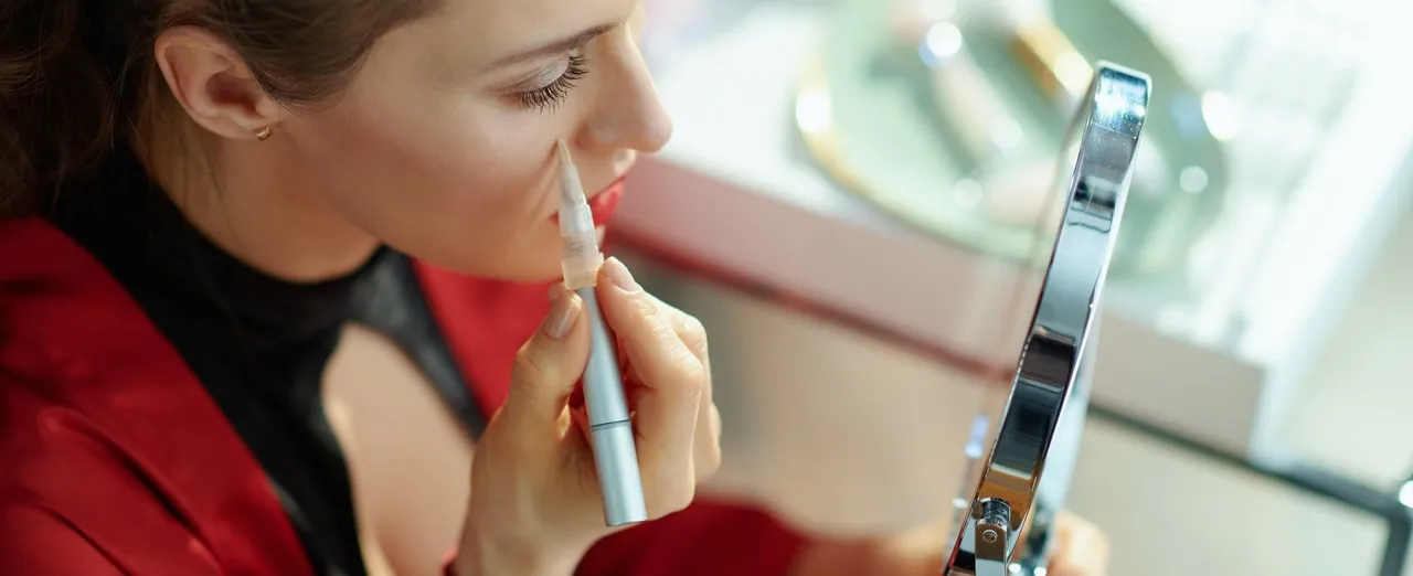 kobieta nakładająca korektor pod oczy