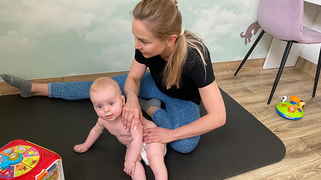 mama podnosząca niemowlę w prawidłowy sposób, fizjoterapeuta niemowlęcy