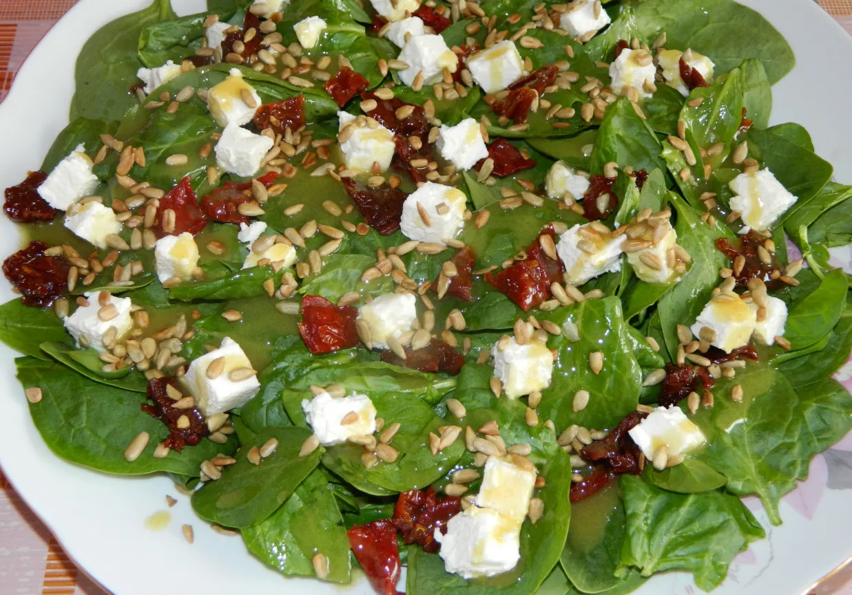 Pyszna sałatka ze szpinakiem, fetą i słonecznikiem, polana sosem.