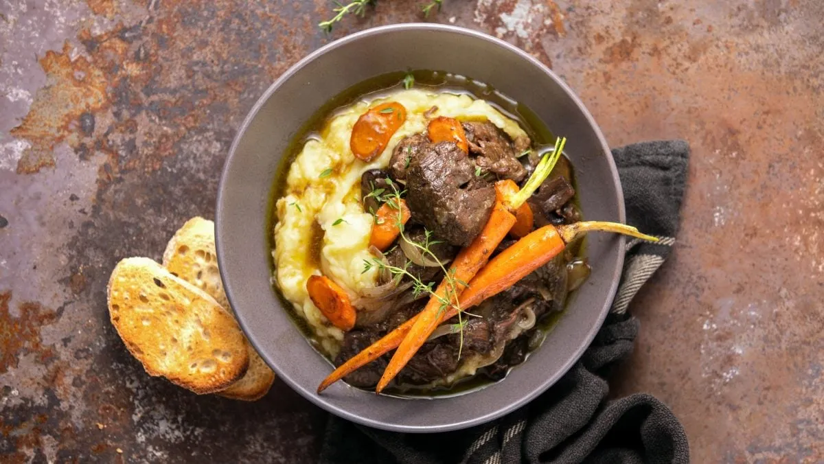 Bœuf Bourguignon in einem rustikalen Schmortopf serviert