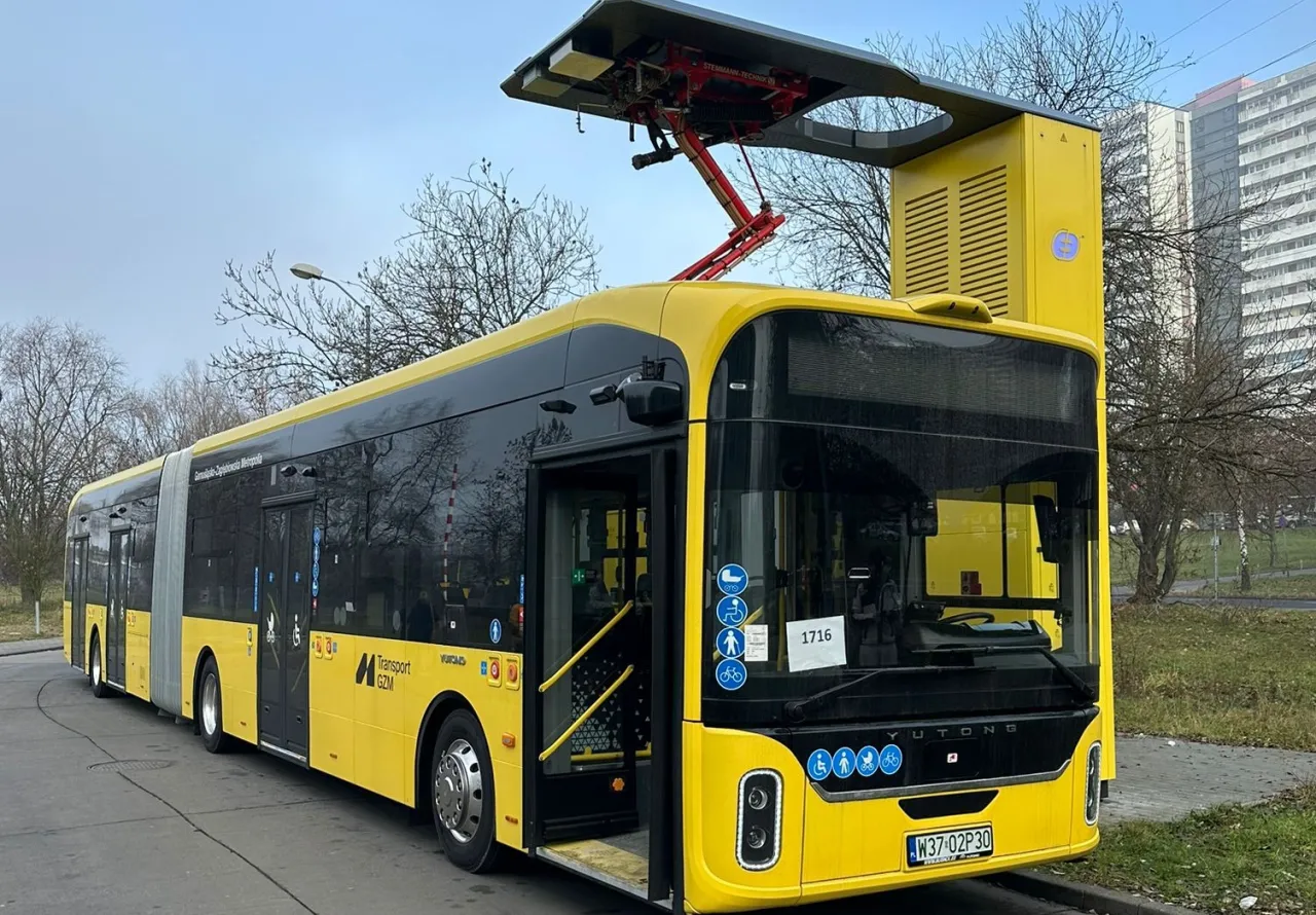 Ż&oacute;łty przegubowy autobus elektryczny z pantografem na dachu, symbolizujący elektromobilność w zam&oacute;wieniach publicznych.