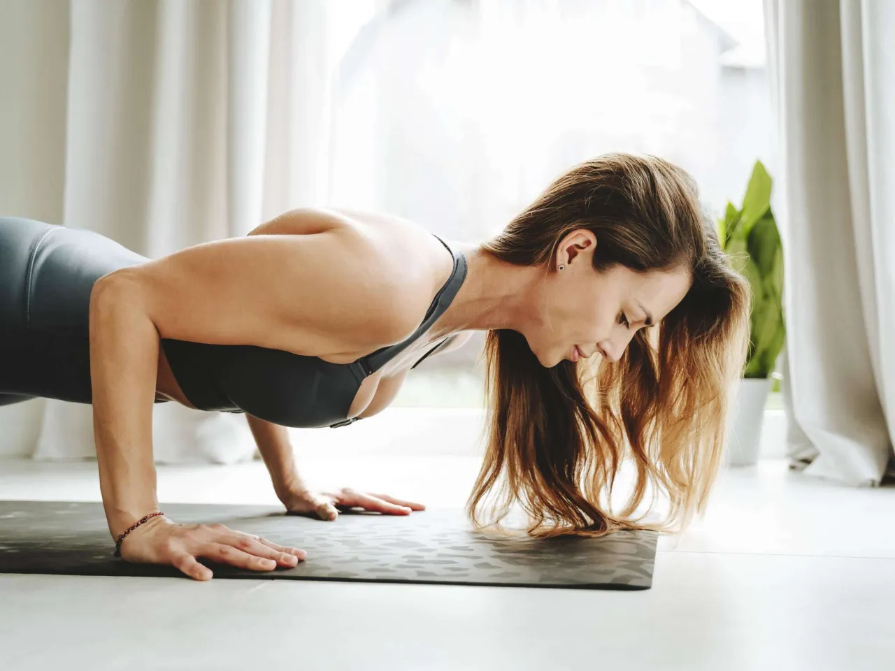 Frau macht Liegestütze zuhause