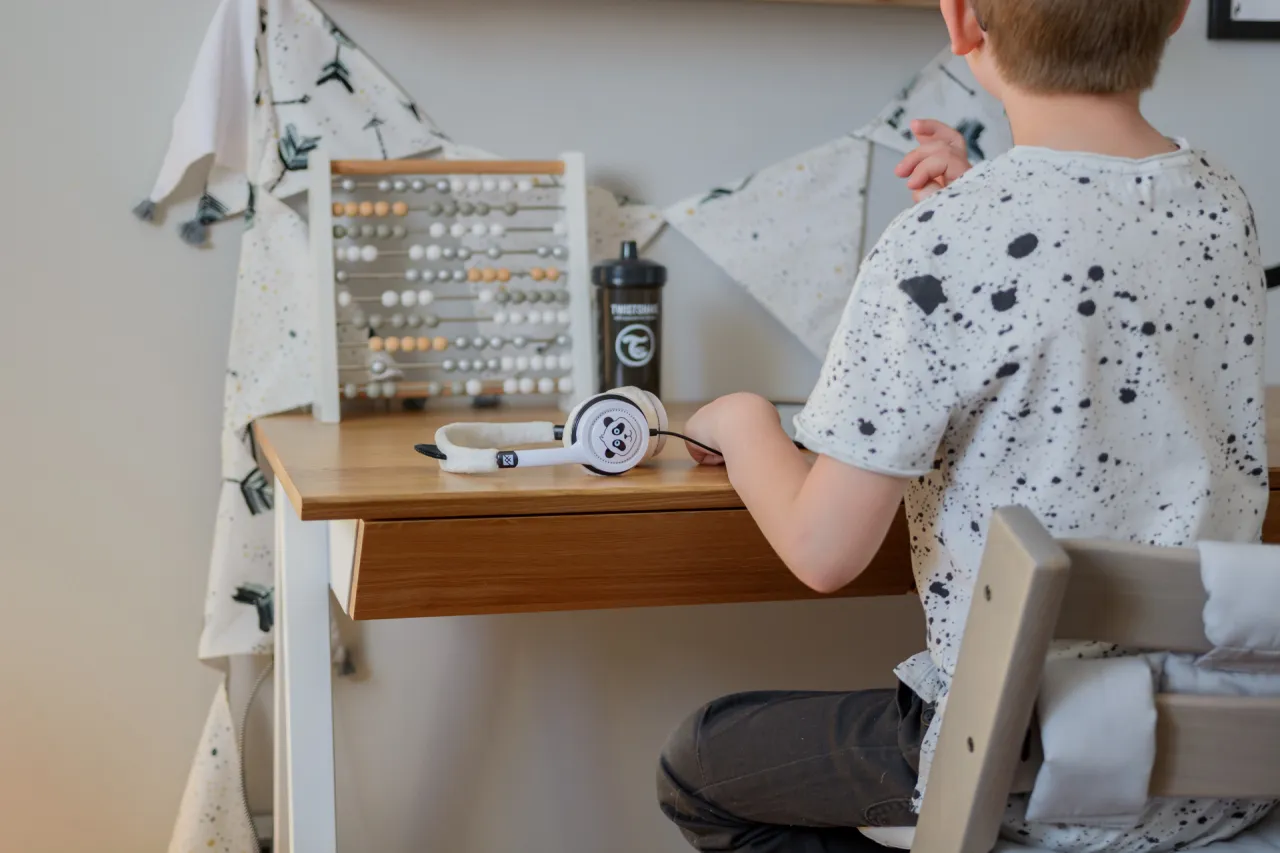 Dziecko siedzące prawidłowo przy biurku kąty proste