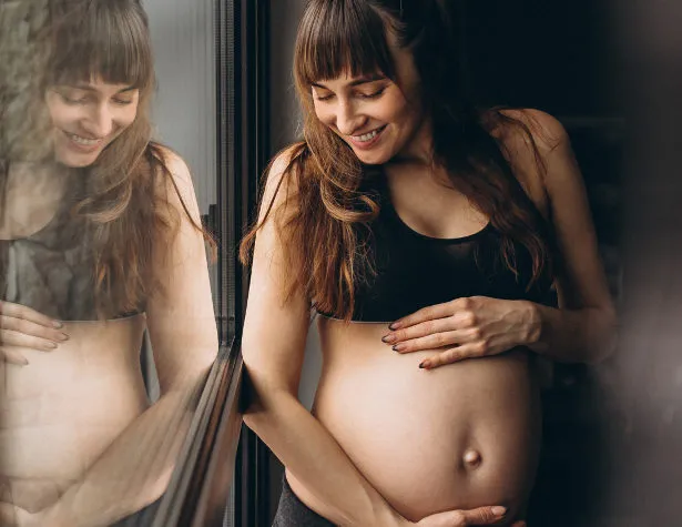 kobieta w ciąży relaksująca się z okładem na czole