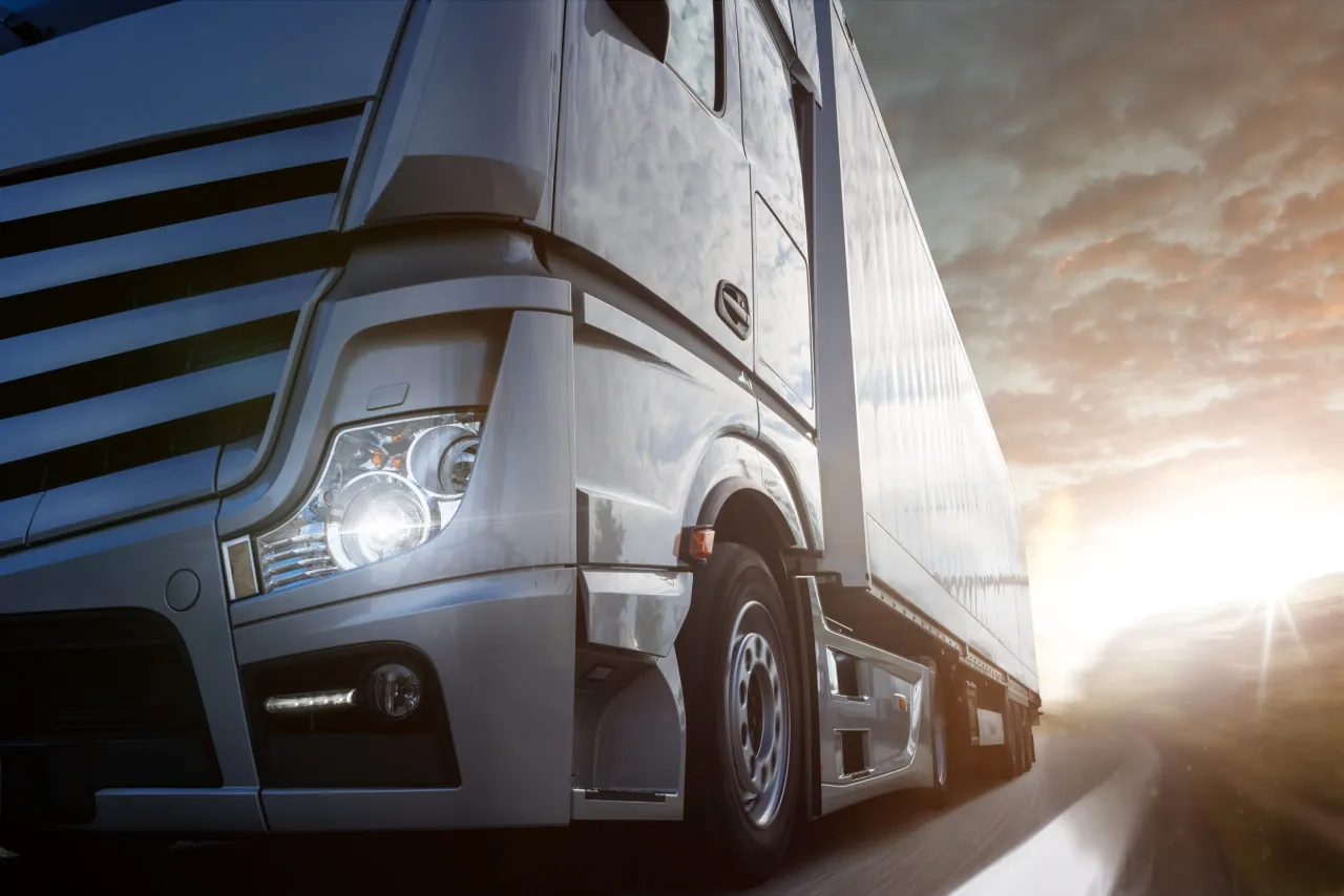 Ciężar&oacute;wka pędzi w stronę zachodzącego słońca. Kierowca martwi się o niezapłacenie składki ubezpieczeniowej w terminie.