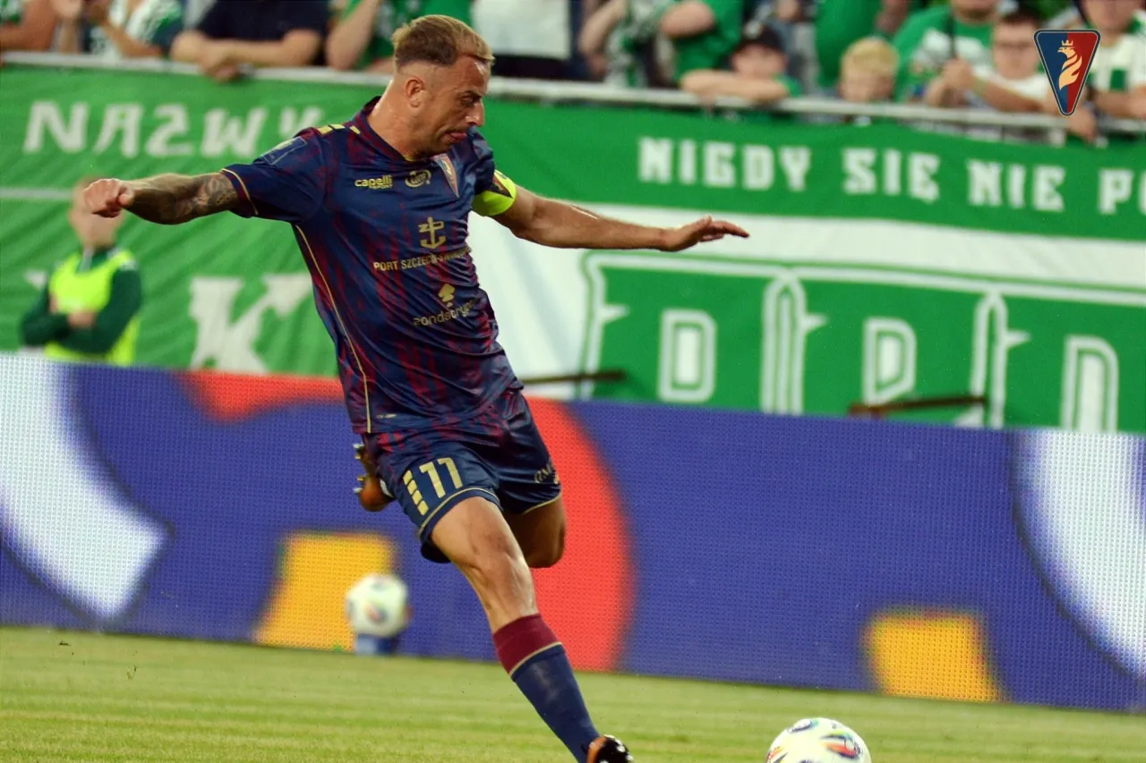 Piłkarz w granatowo-bordowym stroju z numerem 11 na boisku. Czy to właśnie tyle zarabia Grosicki w Pogoni?