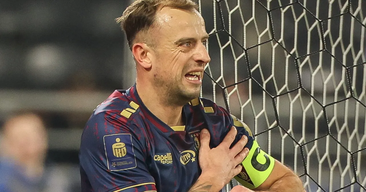 Piłkarz w koszulce Pogoni z opaską kapitana, zaciśnięta pięść na klatce piersiowej. Ciekawe, ile zarabia Grosicki w Pogoni.