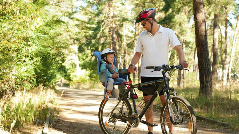 rodzic sprawdzający wagę dziecka do fotelika rowerowego