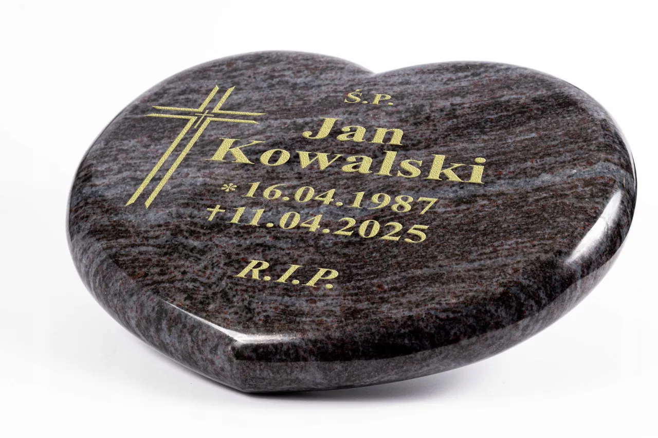 Pracownik grawerujący napis na kamieniu nagrobnym