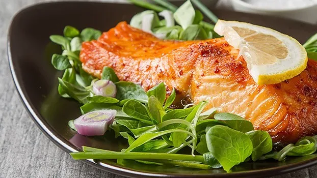 Piatti di salmone con contorni di verdure e riso