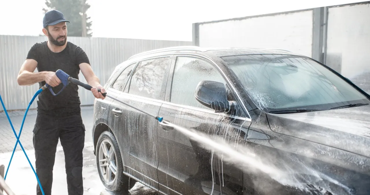 Osoba używająca lancy w myjni bezdotykowej BP