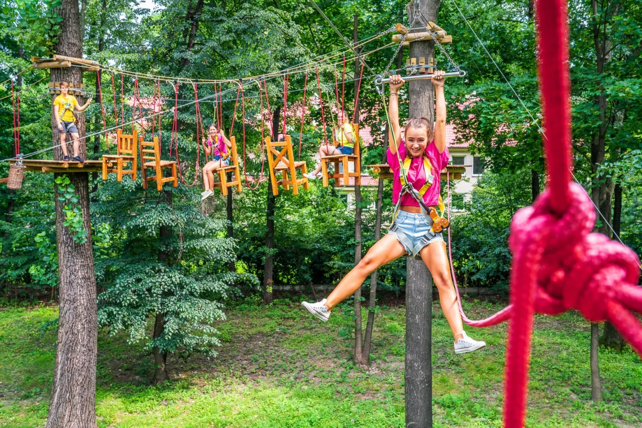 Wesołe dzieci na parku linowym w Katowicach, gdzie z dzieckiem można aktywnie spędzić czas.