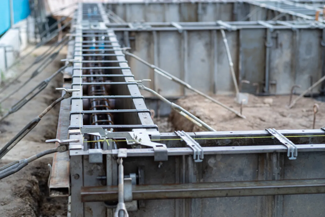 Metalowe elementy szalunku tworzą formę dla betonu, czekając na zalanie. To właśnie szalunek co to za konstrukcja, która nadaje kształt fundamentom.