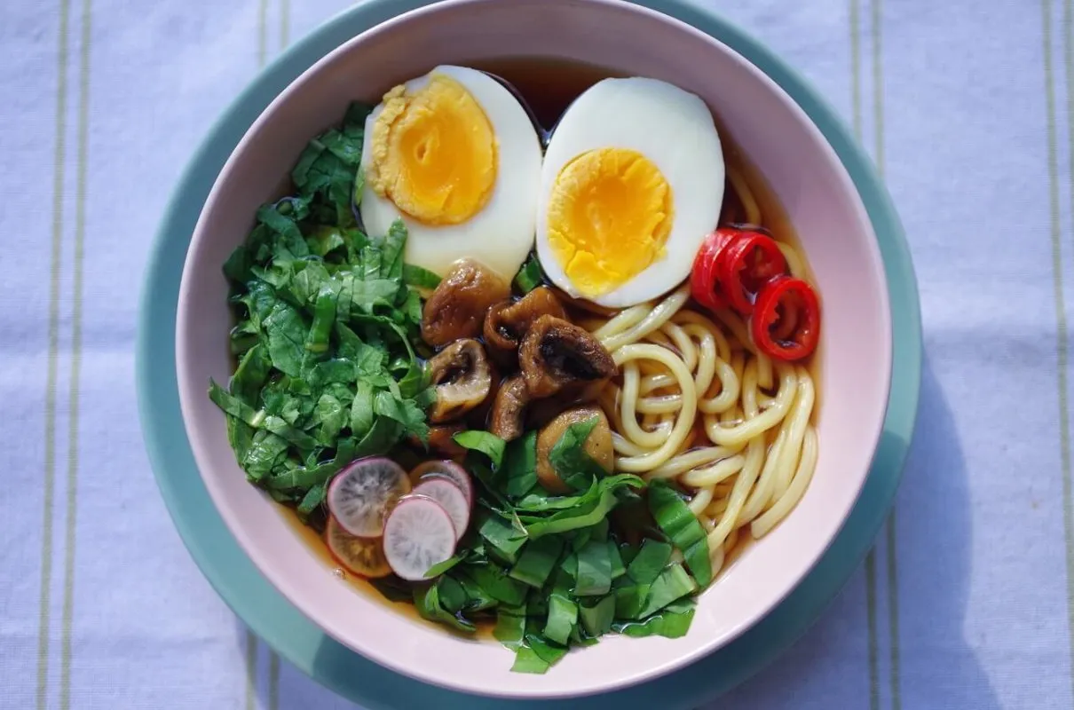 Miseczka ramenu z jajkiem, grzybami, szczypiorkiem i papryczką chili. Zdrowe i smaczne danie, kt&oacute;re nie musi mieć wysokich ramen kalorie.