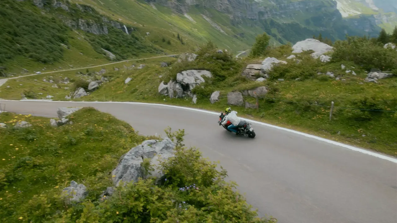 Motocyklista na alpejskiej przełęczy z widokiem