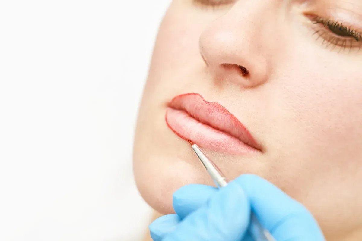 Makijaż permanentny ust etapami, linergistka wykonująca zabieg makijażu permanentnego