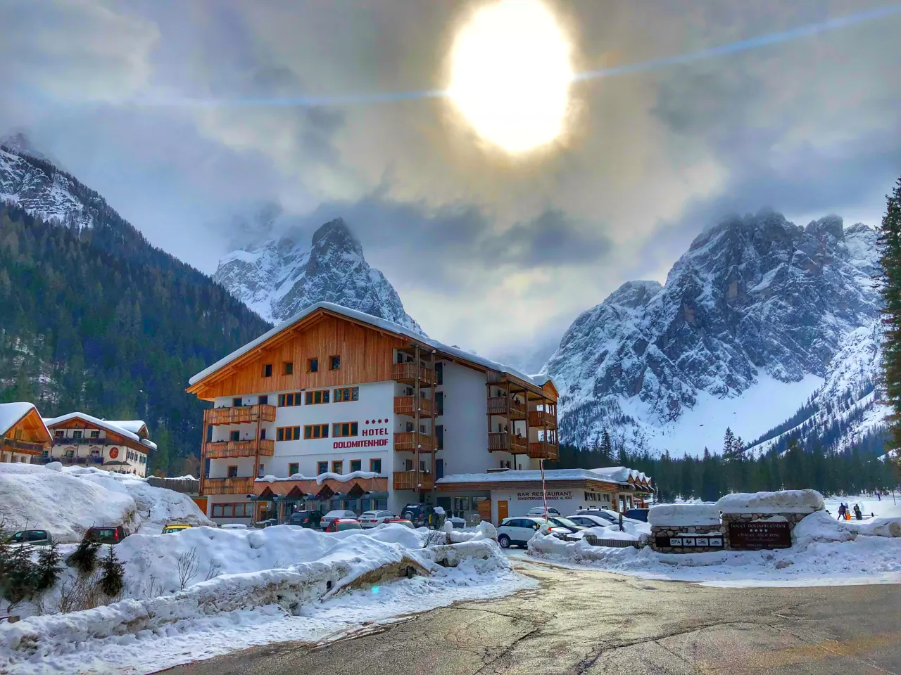 Hotel Dolomitenhof w zimowym Tyrolu we Włoszech, otoczony ośnieżonymi g&oacute;rami i lasami.
