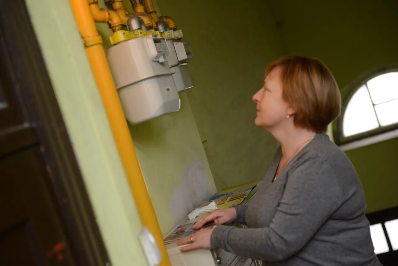 Kobieta przygląda się gazomierzom, zastanawiając się, ile trwa wymiana gazomierza.