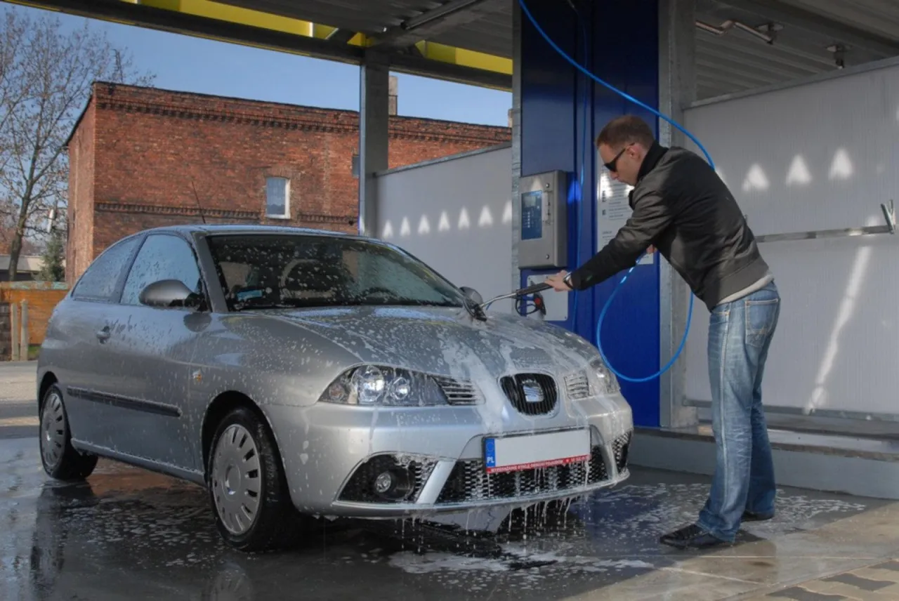 kierowca przygotowuje samoch&oacute;d do mycia myjnia samoobsługowa