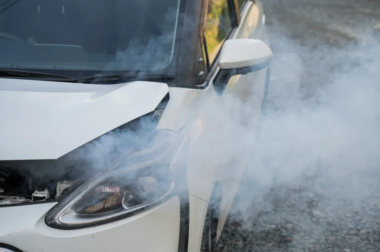 kierowca włącza ogrzewanie w samochodzie, para spod maski, bezpieczne zatrzymanie samochodu na poboczu