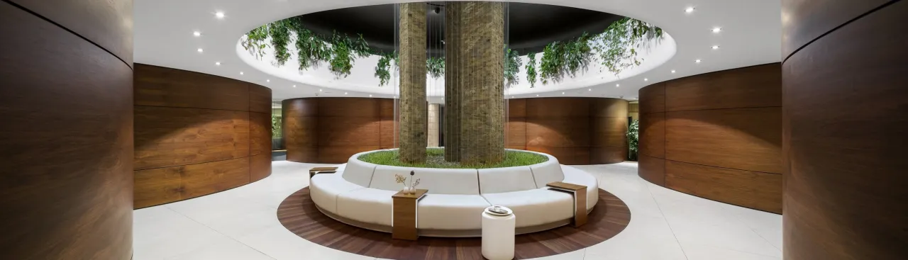 Nowoczesne spa koło Warszawy z centralną, zieloną wyspą i wygodną, białą sofą. Drewniane panele tworzą przytulną atmosferę.
